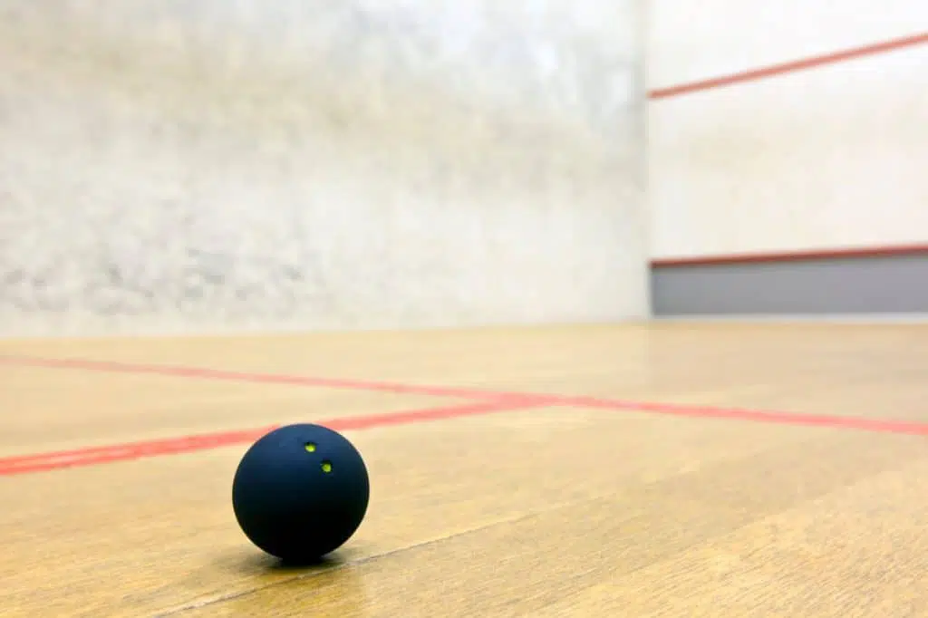 Squash ball on floor of indoor squash court