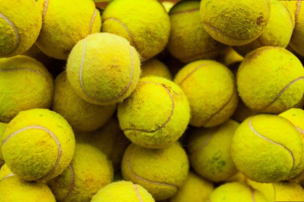A pile of modern green tennis balls, used