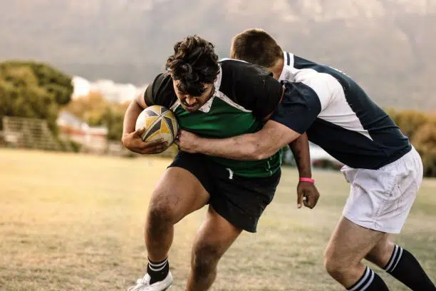 Rugby players tackling one another
