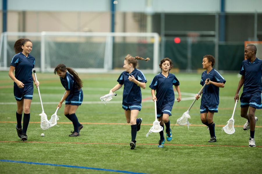 children running while playing lacrosse