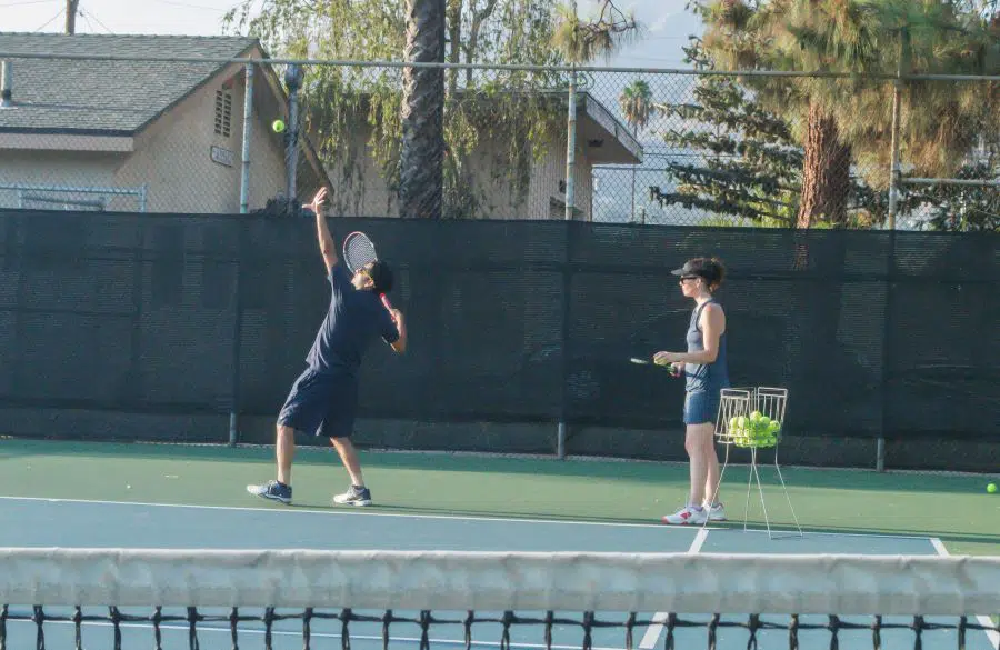 Tennis training with a man working on his serve
