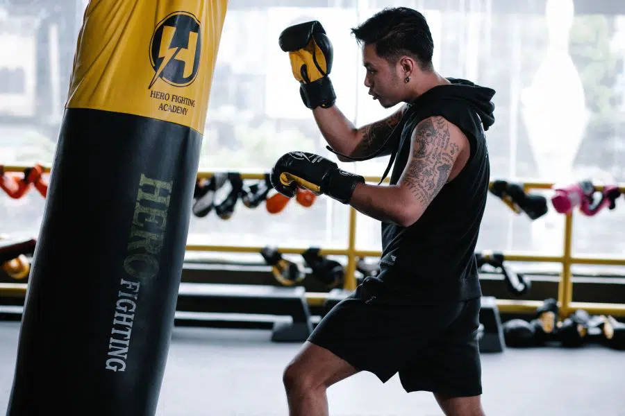 Boxer hitting punch-bag in gym