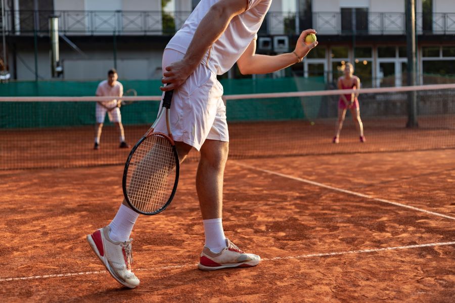 Three tennis players on a clay court