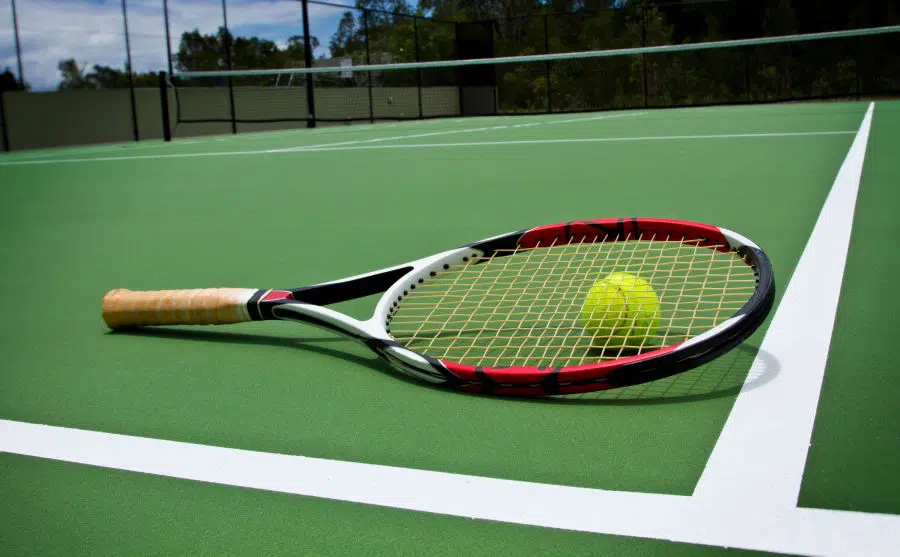 Tennis racket with ball on a court