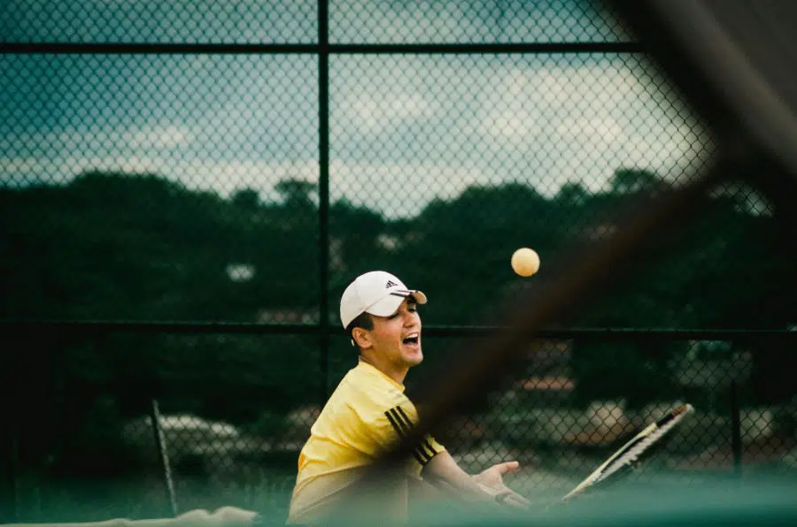 Man grimacing while playing tennis