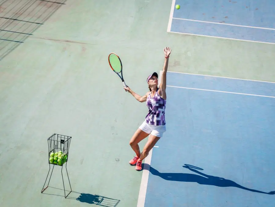 Female tennis player serving on a hardcourt
