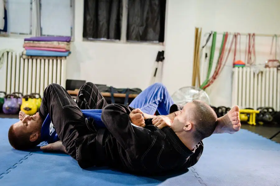 Two BJJ competitors sparring in training
