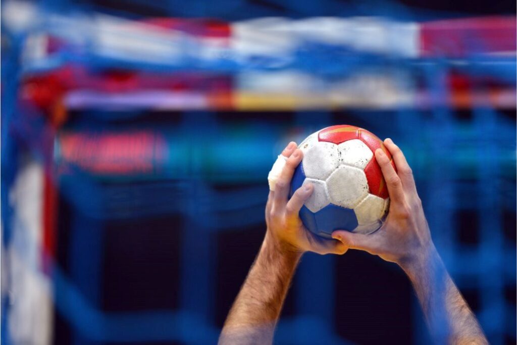A man holding a handball up close